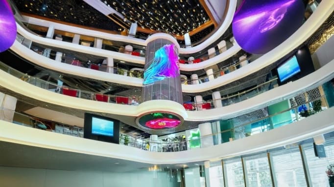 A Transparent Cylinder LED Display Suspended in the Center Creates a Futuristic Commercial Showcase